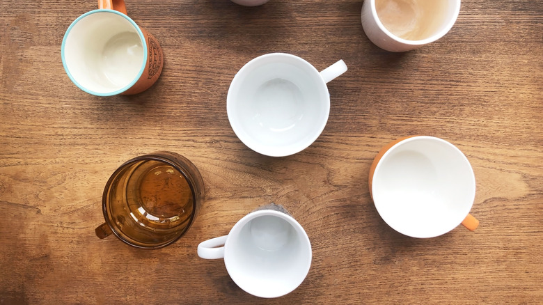 A collection of empty coffee mugs on a wooden table