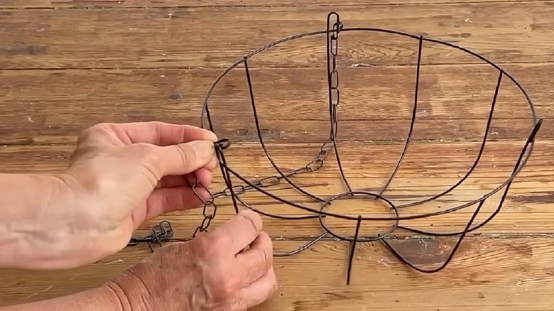 Woman turning wire basket into multi-tiered flower display