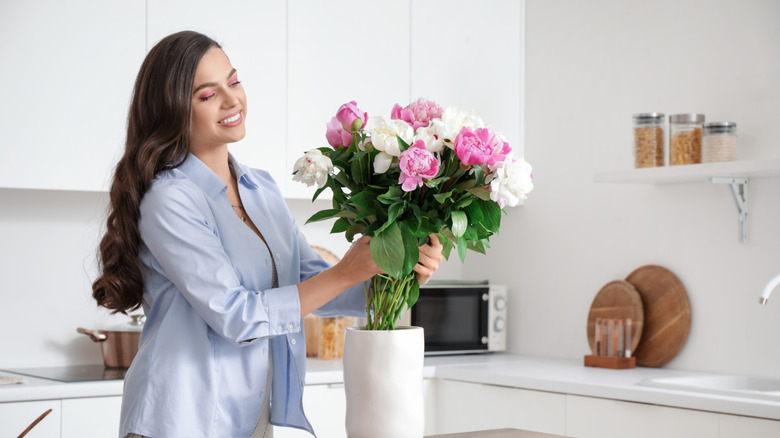 Person arranging flowers in a vase