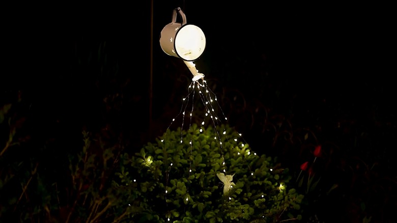 A glowing watering can light fixture
