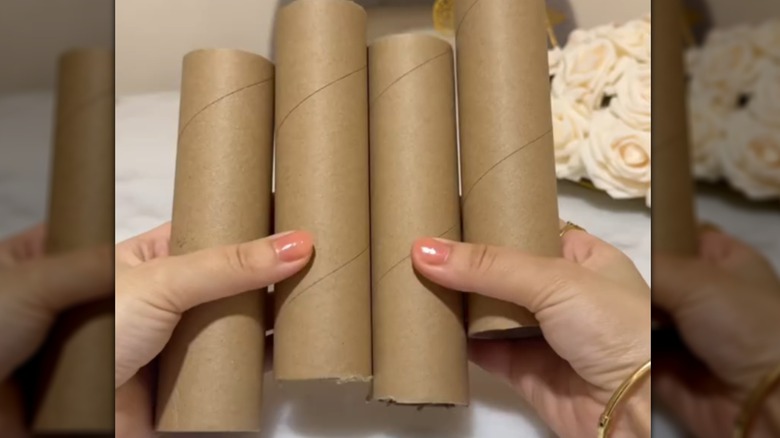Hands holding cut paper towel cardboard tubes