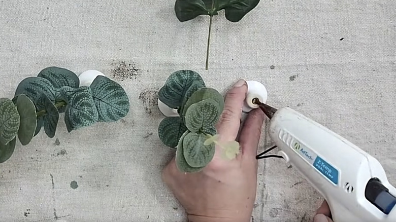 hand applying hot glue to knob