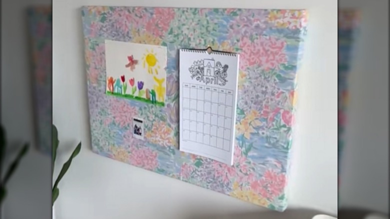 A DIY pinboard made from a large sheet of foam board and an old bed sheet