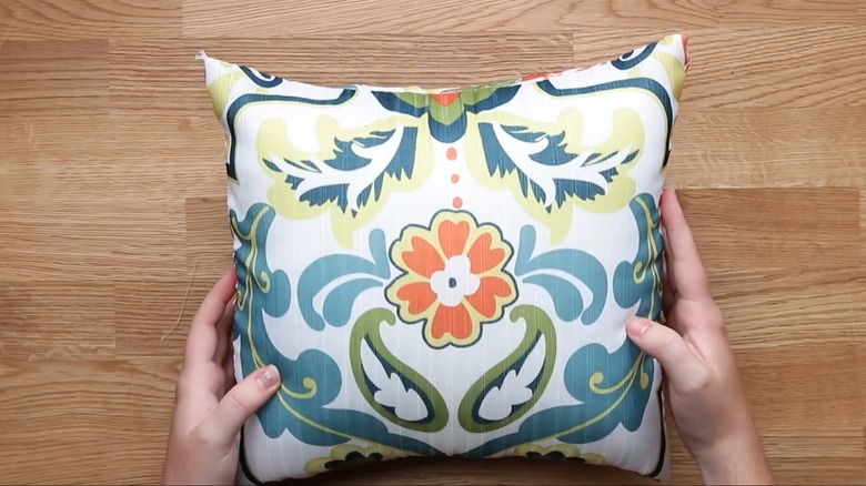 Shower curtain with symmetrical floral pattern upcycled into DIY outdoor pillowcase for smal throw pillow