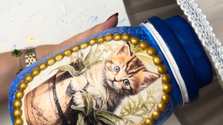 Woman holding DIY cat lamp made from ordinary glass jar