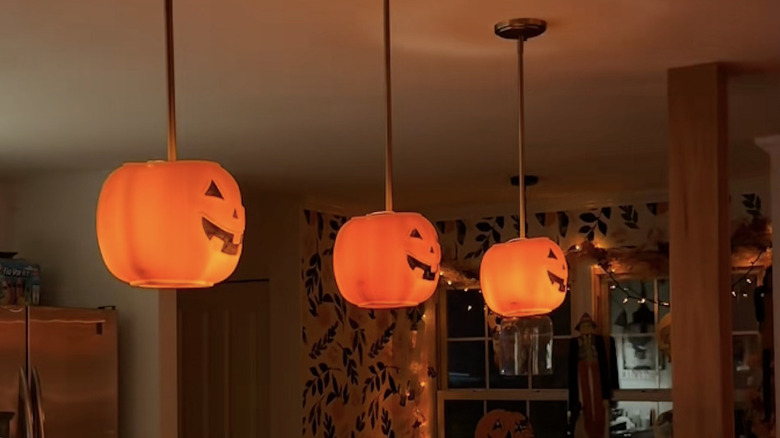 Plastic Jack-O-Lantern buckets hanging from kitchen pendant lights