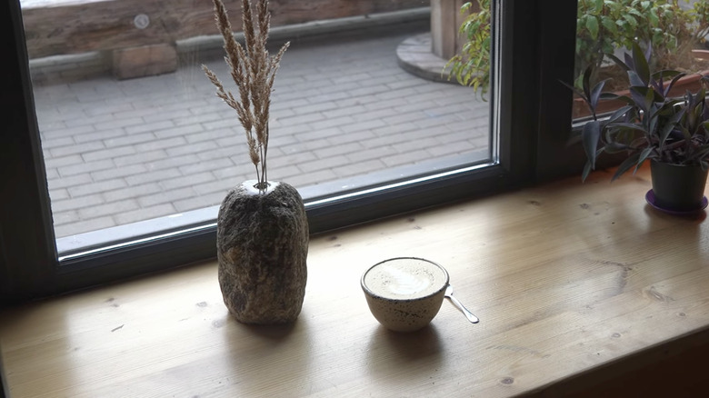 A diy minimalist stone vase set against a window