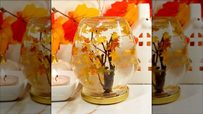 Fall-themed snow globe with small leaves and an autumn tree in it