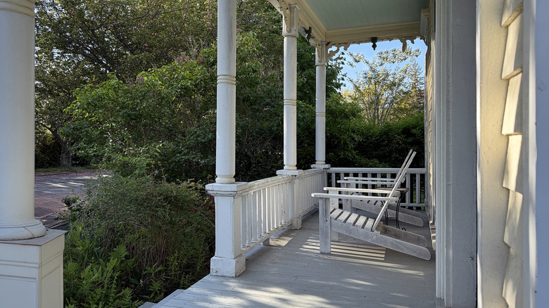 A plain front porch with two Adirondack chairs