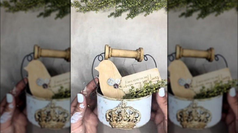Woman holding upcycled tuna can with farmhouse-style decor and a DIY handle