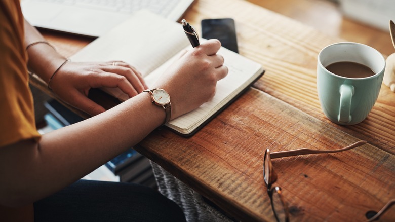 Person writing on a desk in a home office