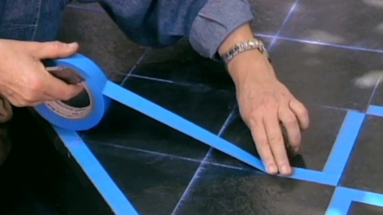 Hands taping squares on a black surface