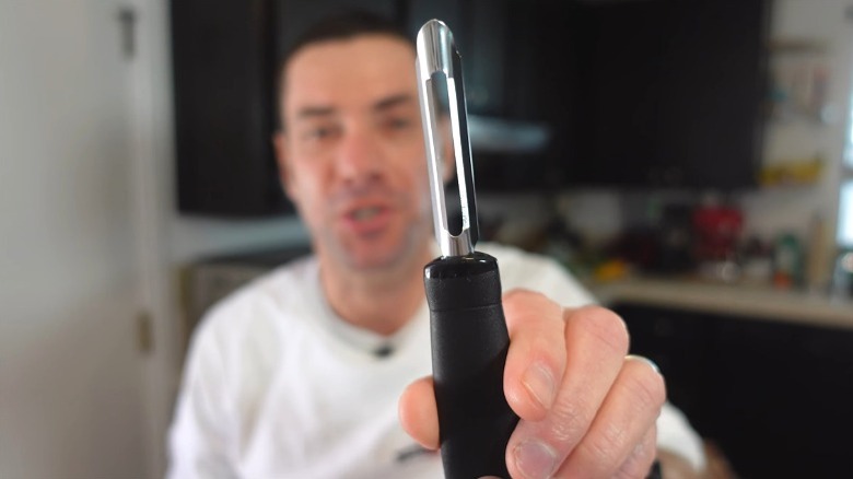 Person holding a potato peeler