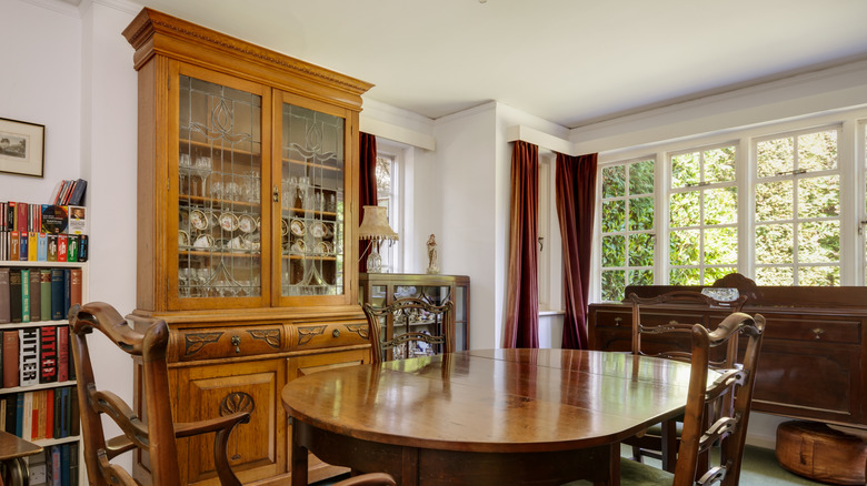 An old honey oak hutch sitting in a dated dining room, England