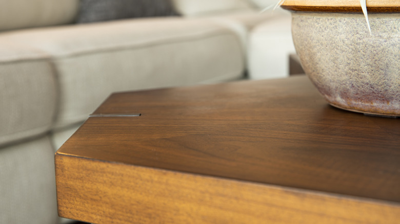 Old coffee table in living room with stone pot on it