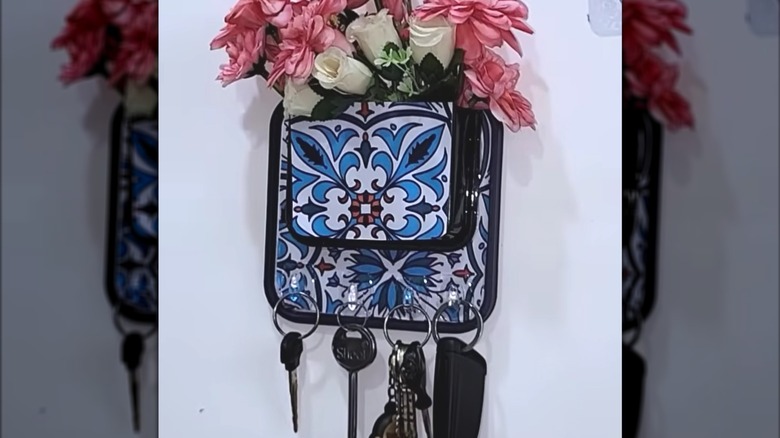Key holder made from a plastic lid with Command hooks to hold the keys and faux flowers at the top