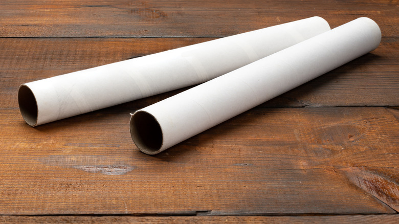 Two empty paper towel rolls on wooden surface