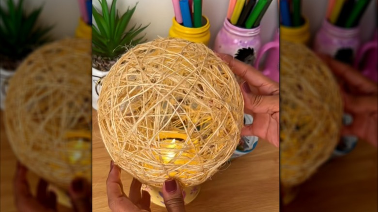 Creator placing the shade on top of the tuna can base for a DIY lamp