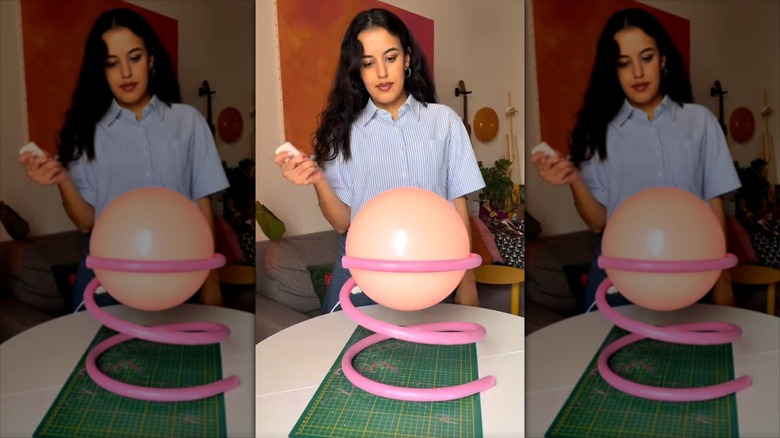A woman turns on a funky lamp created with multilayer pipe and an IKEA FADO lamp