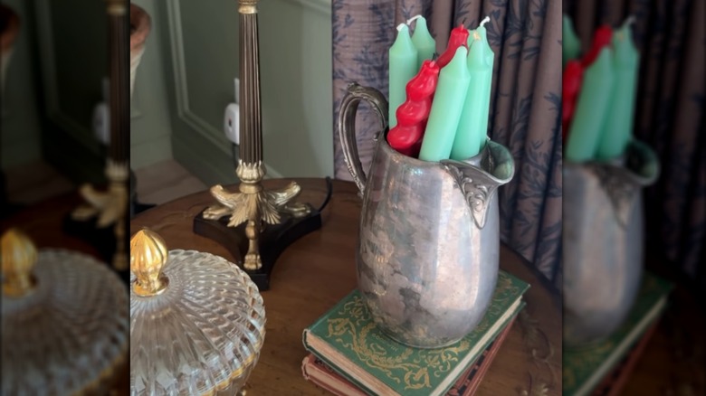 Green and red taper candles inside a thrifted silver goblet