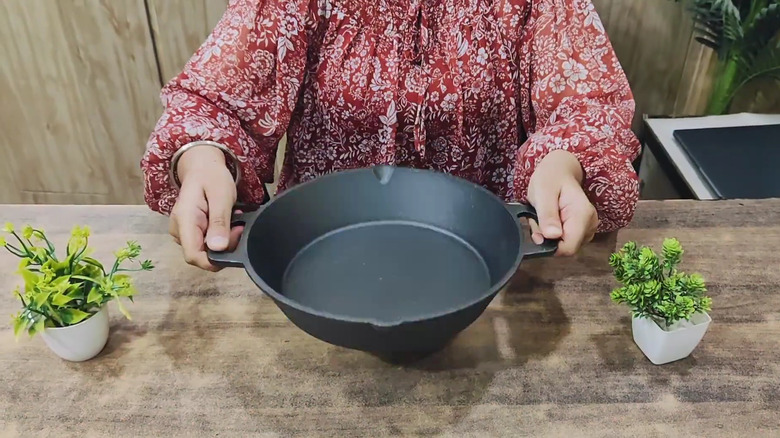 Woman holding dual-handle frying pan