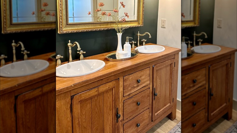 A DIY wooden hutch bathroom vanity with two white sinks and decorative flowers on top