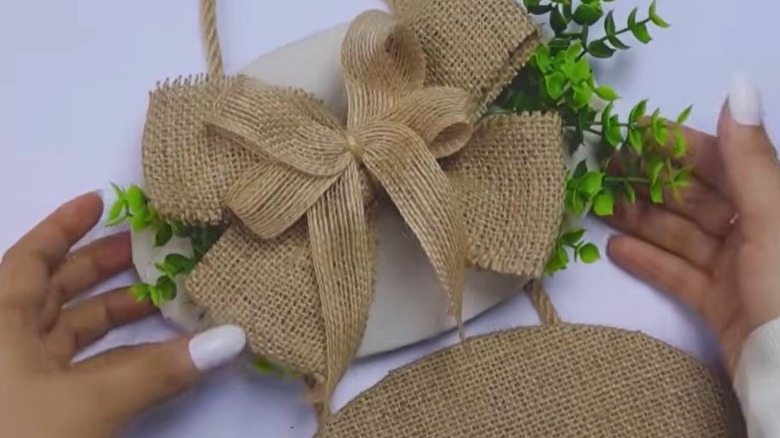 Woman creating DIY welcome sign out of old plastic lids