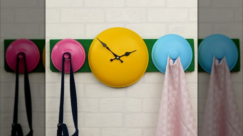 An old metal pot lid repurposed into a yellow clock