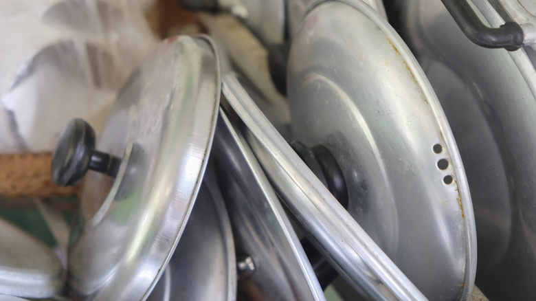 A collection of old metal pot lids