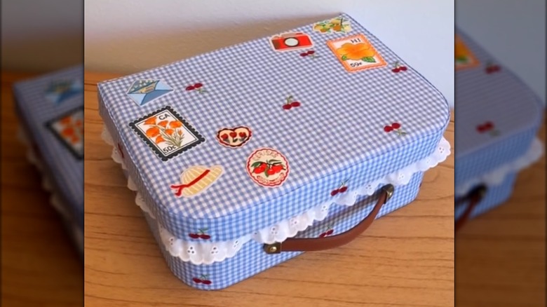 Light blue gingham memory box with vintage patches, ruffle trim, and leather pull on wood table