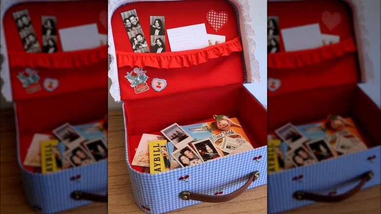 Open repurposed shoe box full of keepsake photos, cards, and miscellaneous items