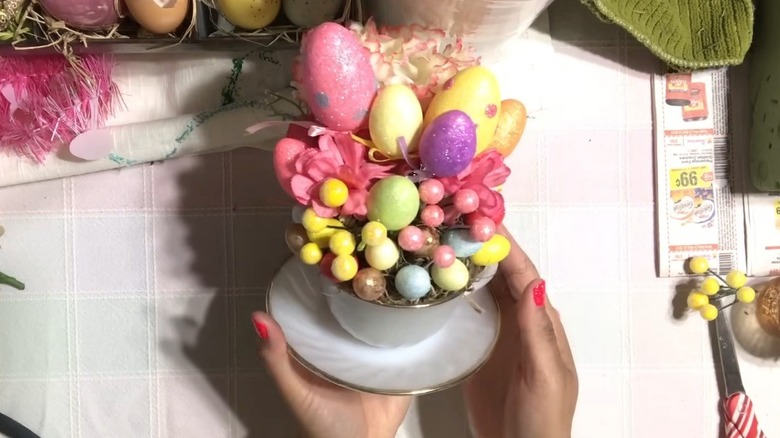 Hands holding teacup filled with Easter decor