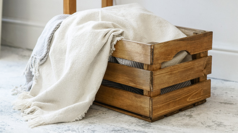 white blanket sitting in an unpainted wooden crate