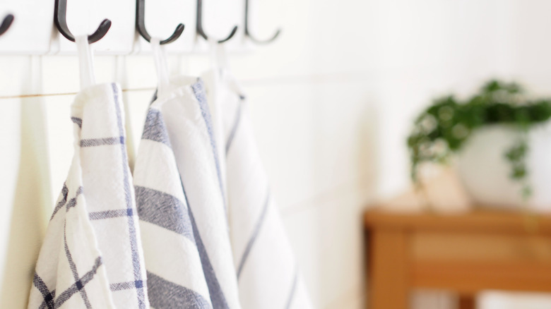 Blue and white kitchen towels hanging on hooks