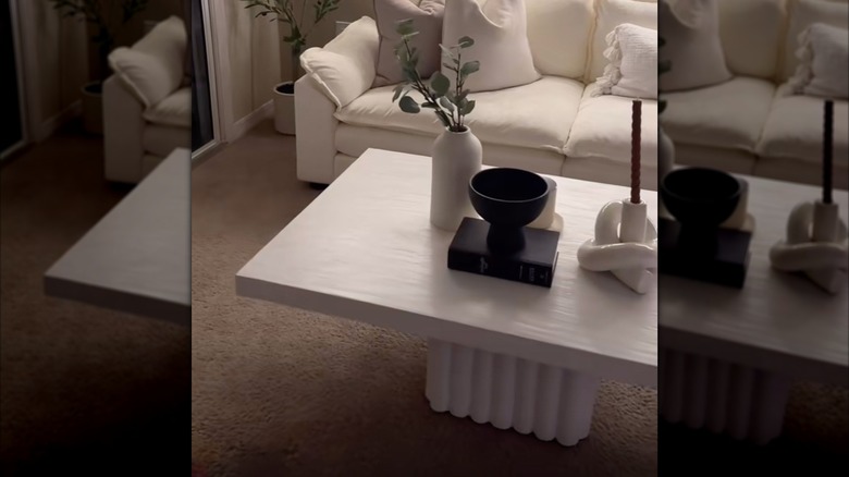 Decorative items sit on a budget-friendly DIY coffee table in a neutral living room