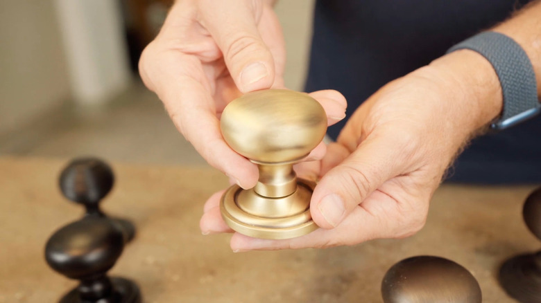 Man holding a golden door knob