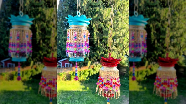 Hanging DIY mason jars transformed into eclectic fairy lights with colorful boho-style hanging beads in backyard