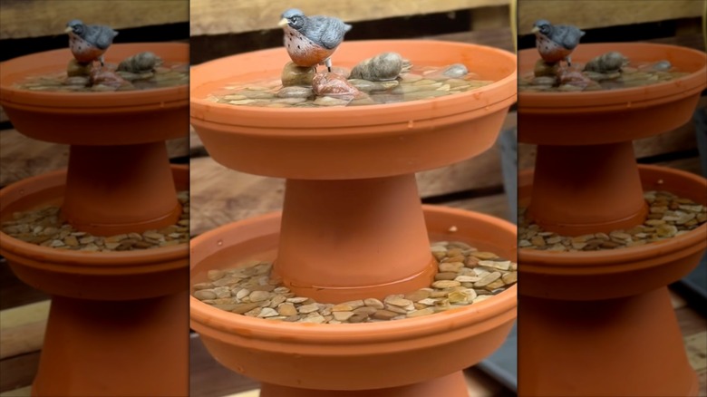 Terracotta colored planters stacked to form a tiered birdbath