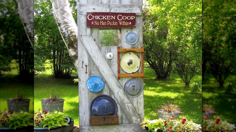 Old pot lids hanging on a wooden bar door as garden decor