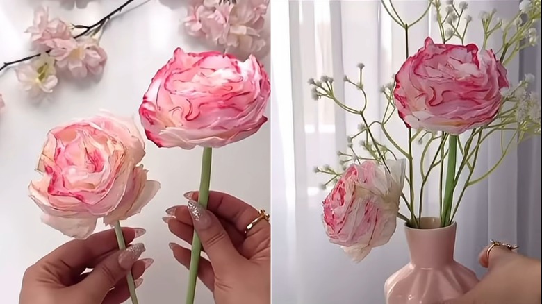 Hands holding paper flowers and paper flowers in a pink vase