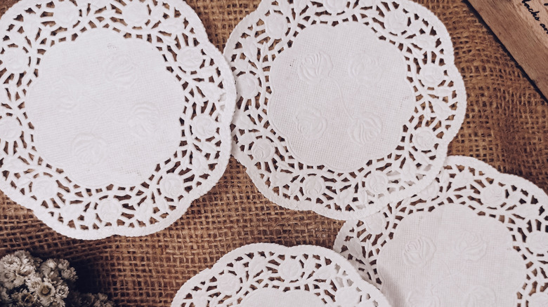 White paper doilies on a burlap surface