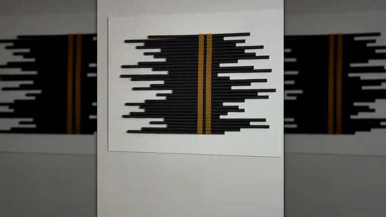 Wall art made from paper straws and gold ribbon