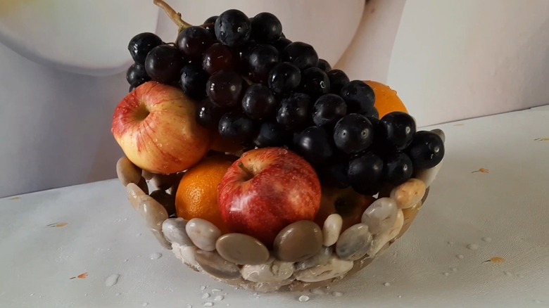 A pebble bowl holding fruits on a countertop