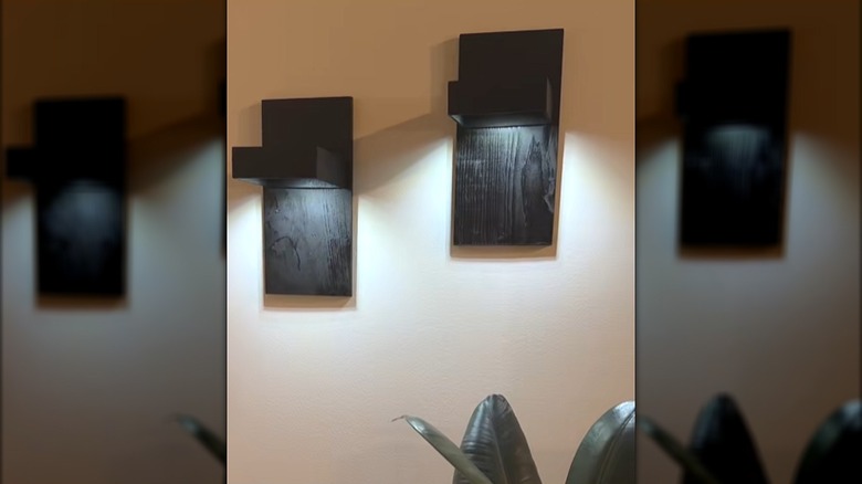 Two DIY wall sconces made from wood planks, wood boxes, and puck lights