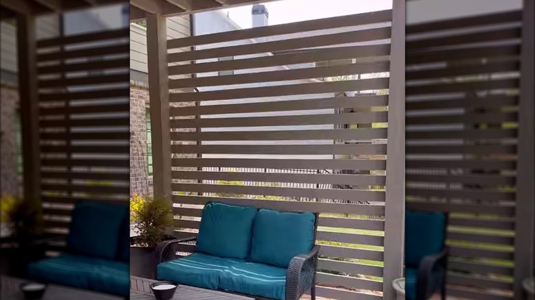 Privacy wall made from wood planks attached to wood deck supports