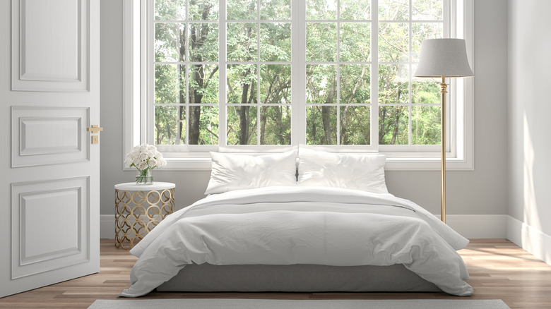 modern gray and white bedroom with empty space on the wall adjacent to the bed