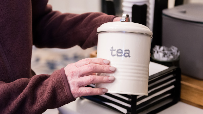Woman holding old tea canister