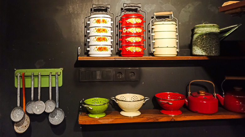 thrift store shelves with colorful metal items including strainers