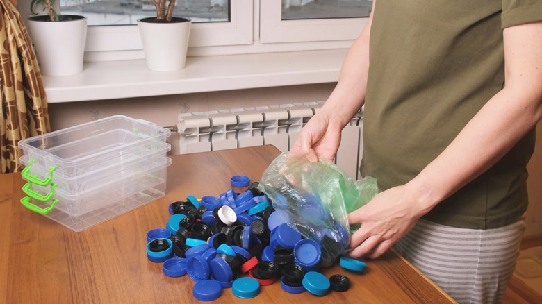 Person pouring plastic bottle caps out of a bag