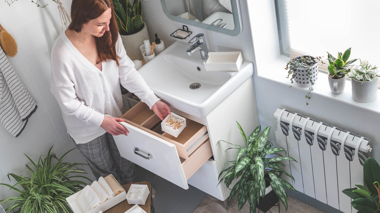 Woman organizing her bathroom with trays